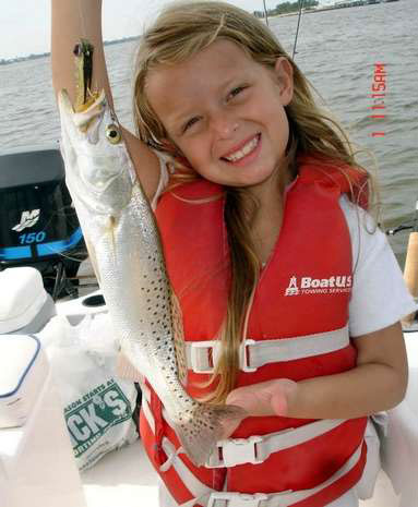 Cute little girl holding a fish she caught